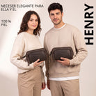 Neceser de piel color zamora marrón, vista frontal con asa de muñeca, con logo STILORD, sostenido por hombre y mujer