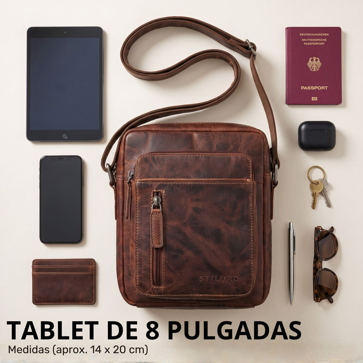 Kleine braune Leder-Schultertasche (luino) mit Frontreißverschluss und Schulterriemen, 8-Zoll-Tablet und Alltagsgegenstände arrangiert